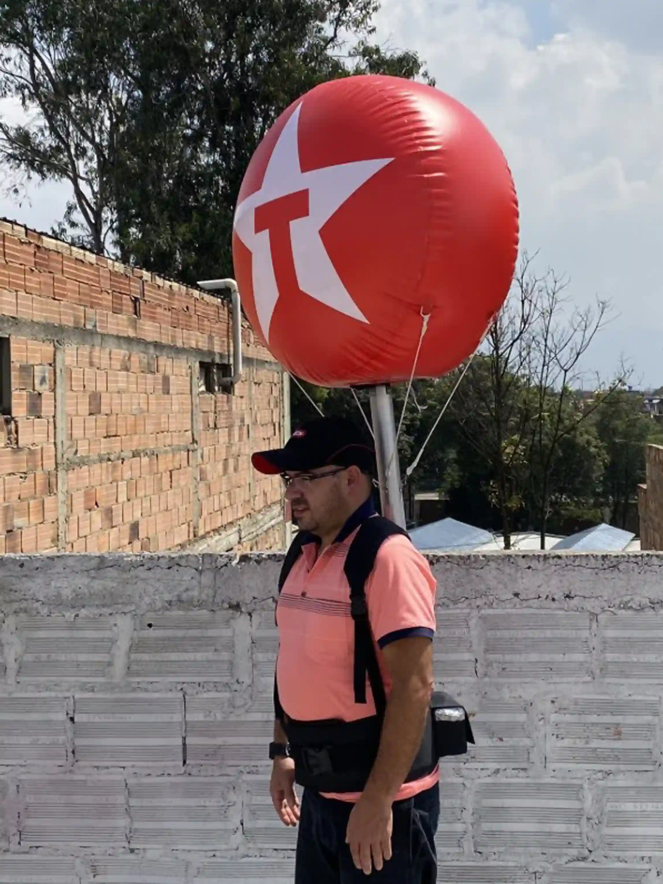 Hombre cargando un Globo móvil rojo en la espalda para la promoción de la empresa Texaco