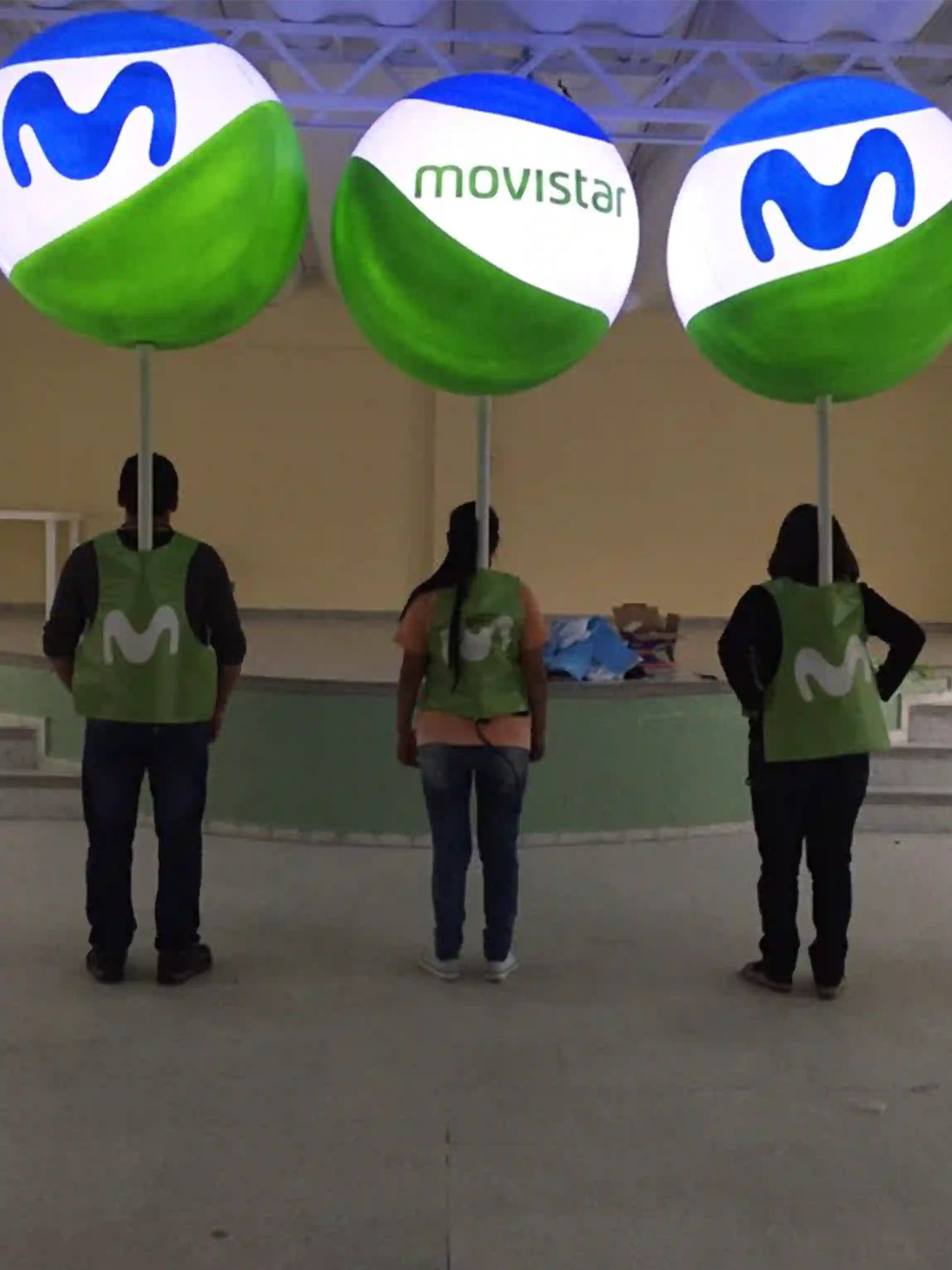 Tres personas cargando un globo móviles para la marca movistar con iluminación interior